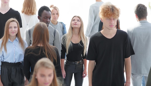 Serious woman standing in front of casual group of young people