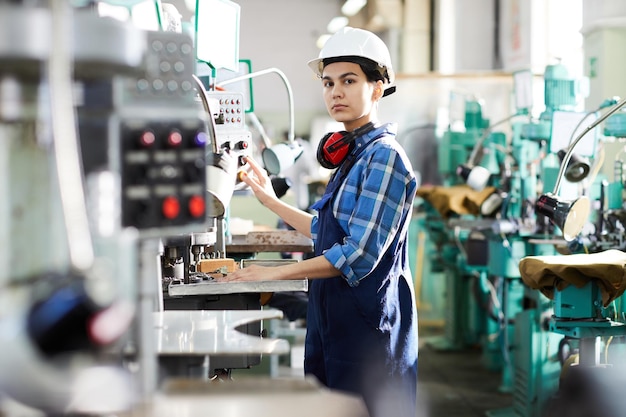 Serious woman working at production line