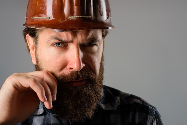 Serious workman in hard hat builder concept building industry technology bearded builder in hard hat