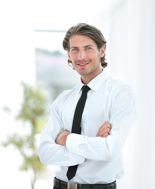 Serious young businessman on the background of office