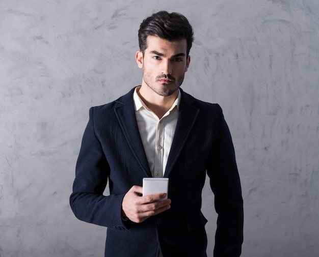 A serious young businessman using a smartphone