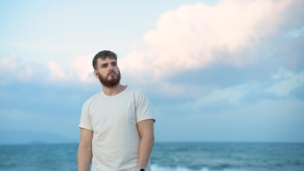 Serious young man on the beach summer sea with beard