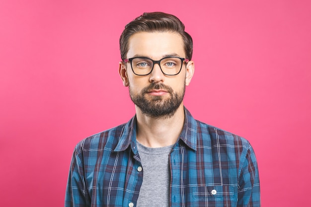 Serious young man in glasses with a beard. No emotion on face.