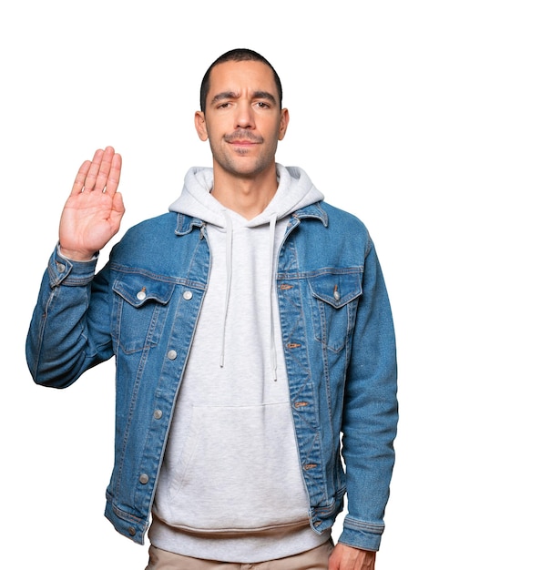 Serious young man making a gesture of stop with his palm