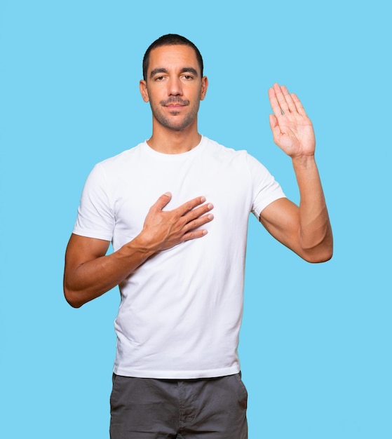 Serious young man with a gesture of oath