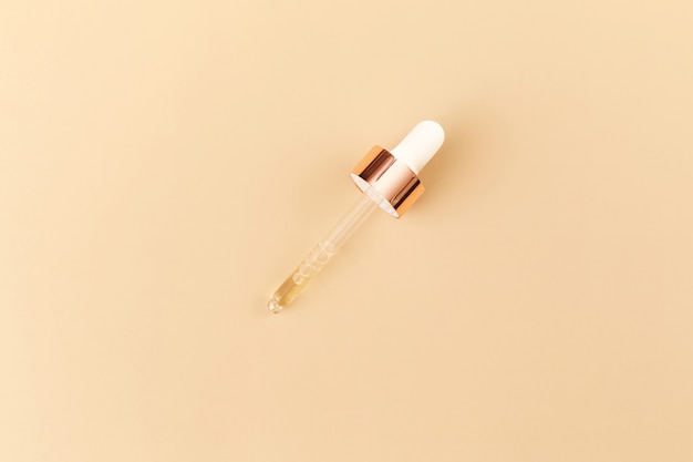 Serum with pipette isolated on beige