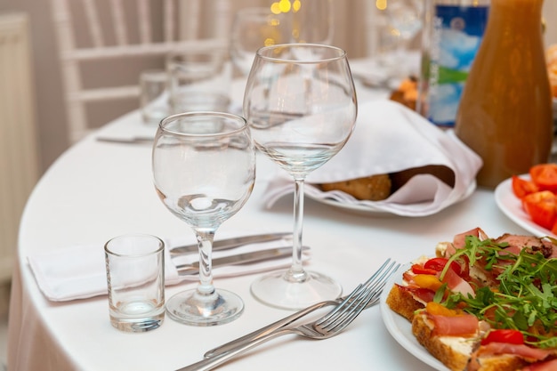 Served for holiday banquet restaurant table with dishes snack cutlery wine and water glasses