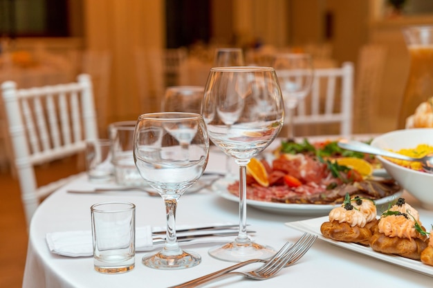 Served for holiday banquet restaurant table with dishes snack cutlery wine and water glasses