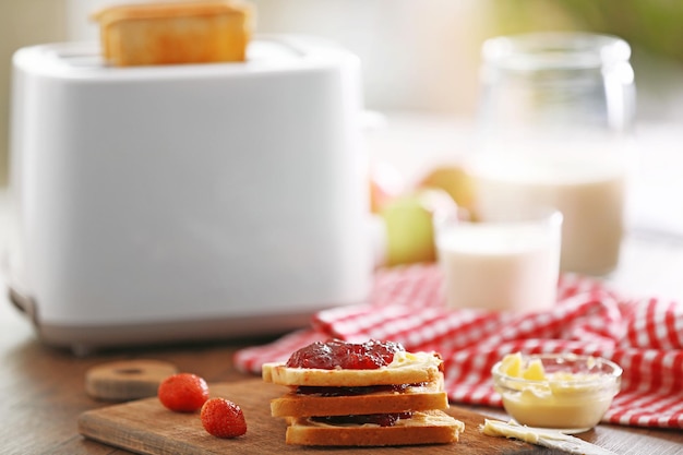 Served table for breakfast with toast milk and jam closeup