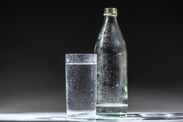 Served table set of mineral water bottle and glass