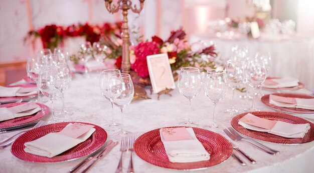 Served table with plates ant glasses decorated by flowers . High quality photo