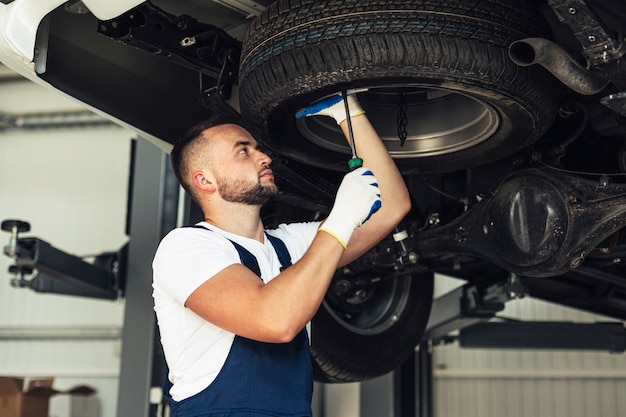 Service car male employee checking car wheels