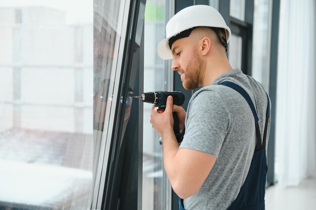 Service man installing window with screwdriver