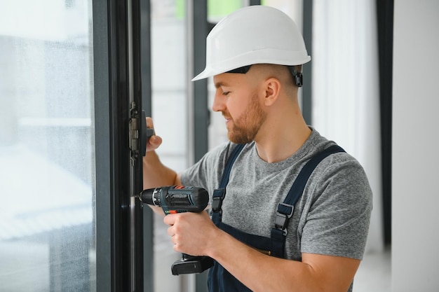 Service man installing window with screwdriver