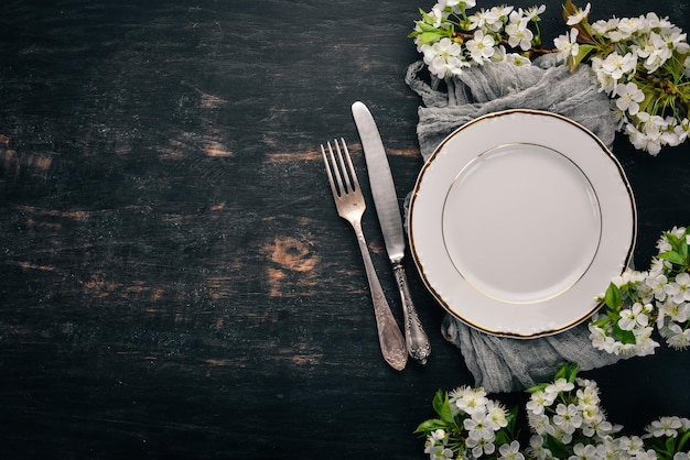 Serving table in spring style Fresh flowers Top view On a wooden background Copy space