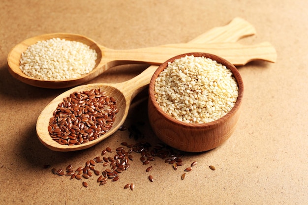 Sesame and flax seeds on beige background closeup