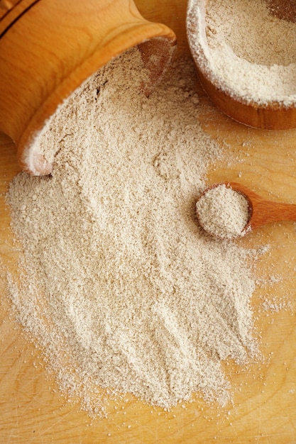 Sesame flour in a clay bowl on wooden background