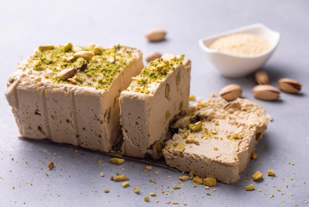 Photo sesame halva with pistachios on grey background top view copy space traditional middle eastern sweets jewish turkish arabic national dessert turkish delight