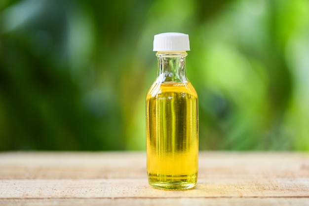 Photo sesame oil in glass bottles on wooden and nature green