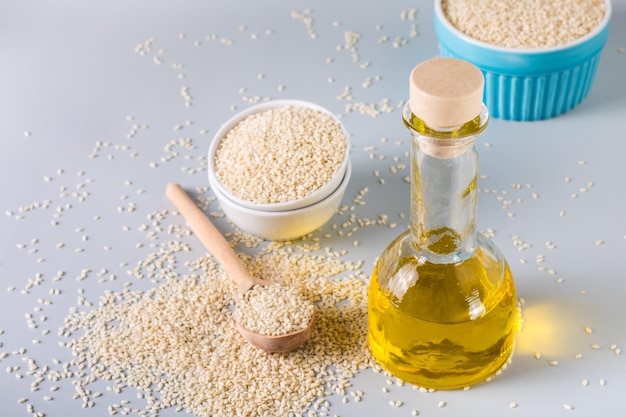 Sesame oil in a glass and seeds in a bowl on the table Organic Alternative Food