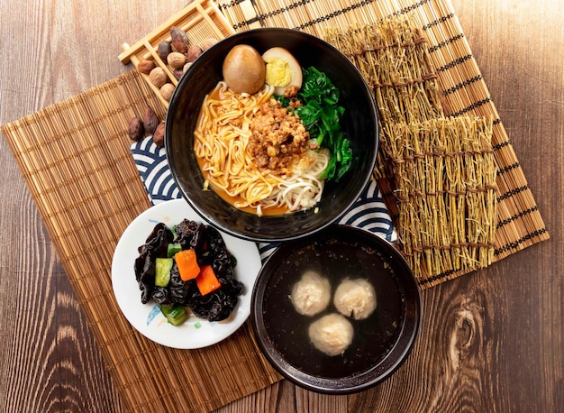 sesame paste noodles with Black Fungus meatballs soup minced pork meat preserved egg and chopsticks served in plate isolated on napkin top view on table taiwan food