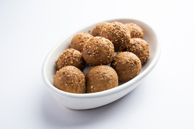 Sesame seed jaggery ball or til ke laddo and tilgul or til gul laddu served in bowl for Makar Sankranti Festival in India