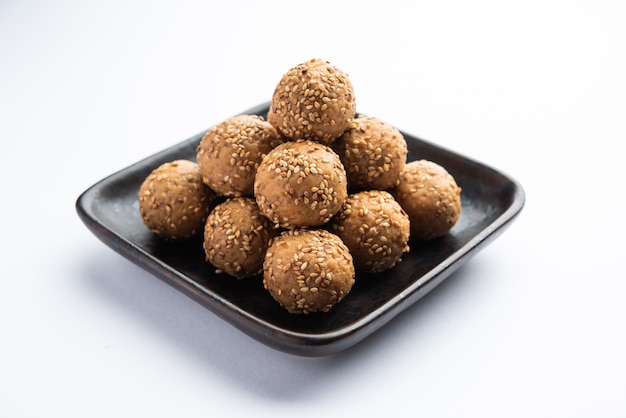 Sesame seed jaggery ball or til ke laddo and tilgul or til gul laddu served in bowl for Makar Sankranti Festival in India