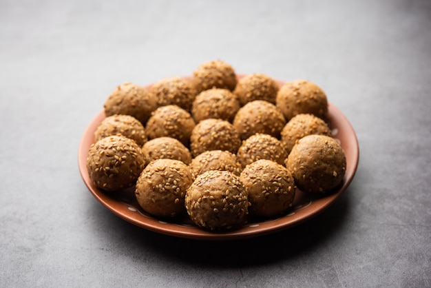 Sesame seed jaggery ball or til ke laddo and tilgul or til gul laddu served in bowl for Makar Sankranti Festival in India