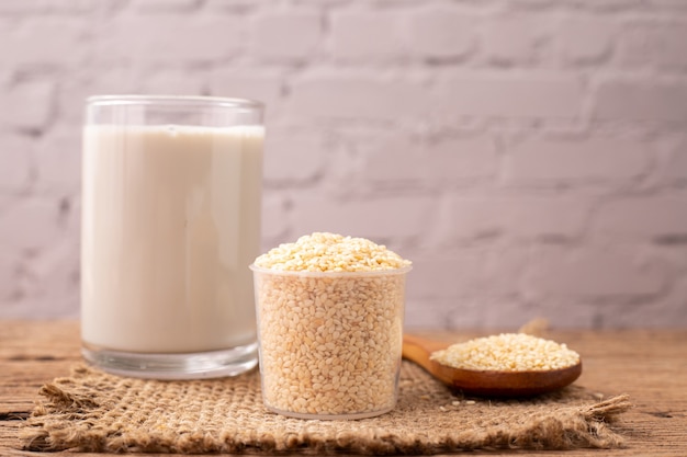 sesame seeds and glass of sesame milk on wood table