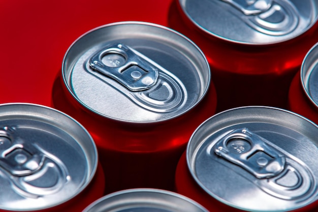 Set of aluminum cans on red background, top view. Recycling packaging to save our planet.