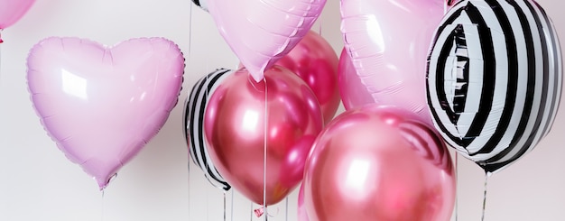 Set of balloons in the form of a heart and round pink and striped on light background with copy space.