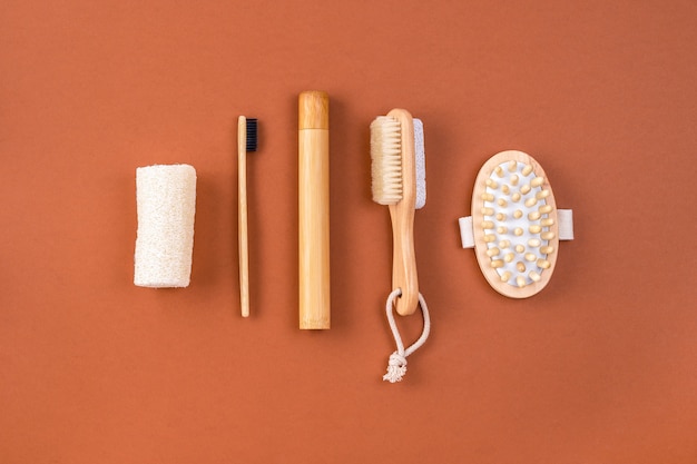 Set of bathroom accessories. Anti cellulite massager, bamboo toothbrush, loofah sponge, peeling brush on brown. Zero waste concept. Minimalistic style.