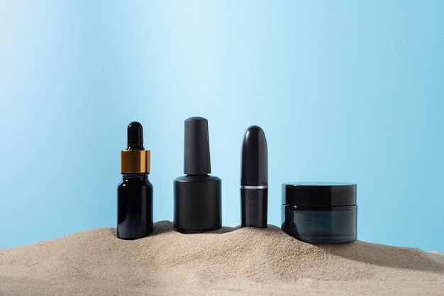 Set of black cosmetics on the sand closeup