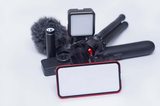 Set of blogging gadgets Smartphone mockup with a white screen with a tripod power bank with an action camera and a stabilizer with a microphone on a white background