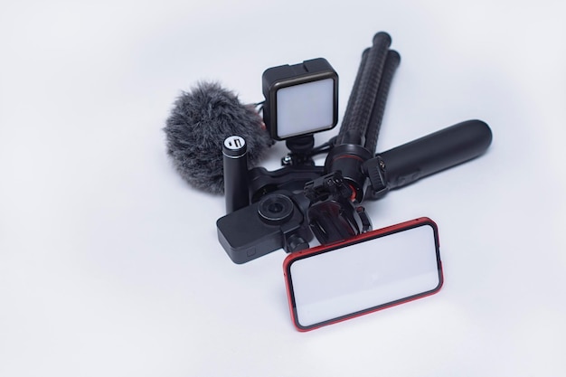 Set of blogging gadgets Smartphone mockup with a white screen with a tripod power bank with an action camera and a stabilizer with a microphone on a white background