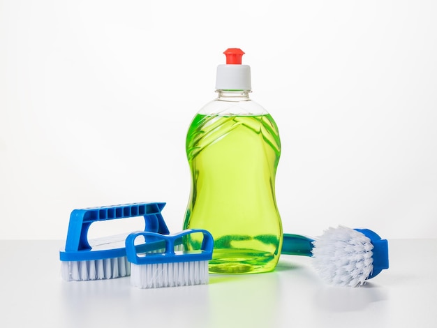 A set of blue brushes and a bottle of green gel on a white table