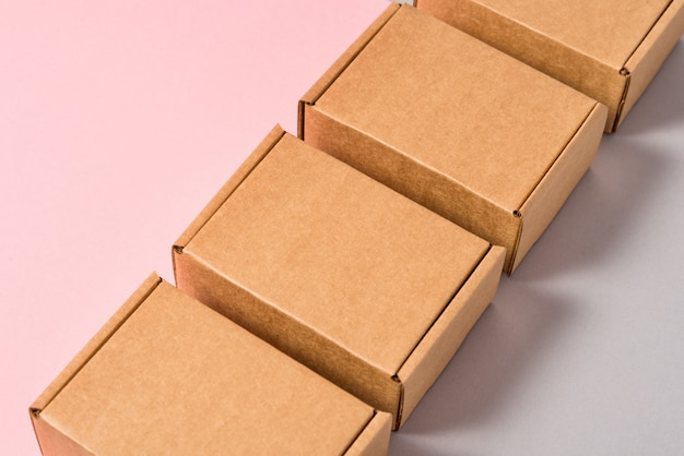 Set of brown cardboard boxes on pink and grey background