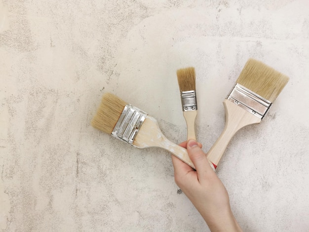 A set of brushes for painting in the hand Beige background Repair in the apartment