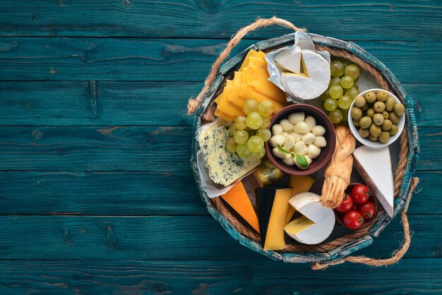 A set of cheese in a wooden box Parmesan Mamasam Mozzarella Brie Feta Top view On a wooden background Free space for your text