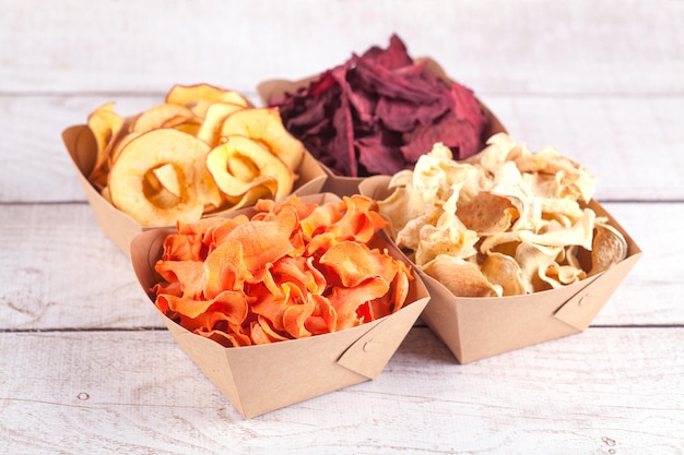 Set of chips from vegetables and fruits in craft bowls. Dried vegetables and fruits. An organic snack for the whole family. Healthy eating concept