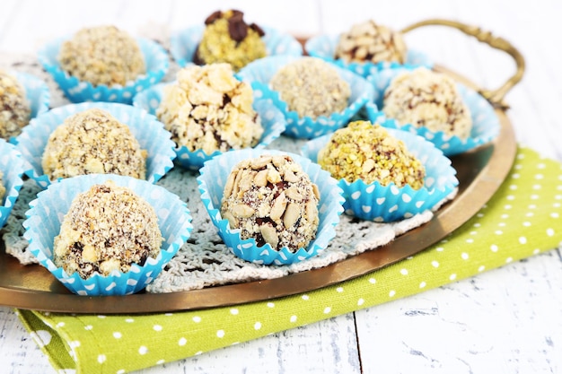 Set of chocolate candies, on tray, on color wooden background