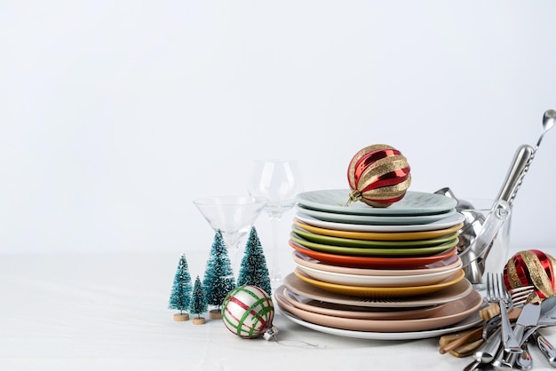 Set of colorful tableware with plates cutlery and glasses with holiday decorations on dining table copy space