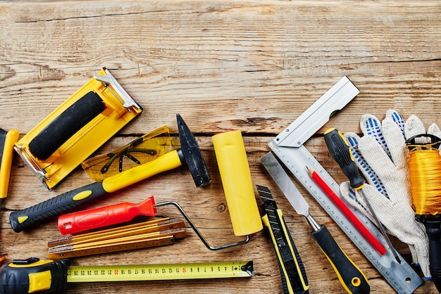 Set of construction tools on a wooden background top view