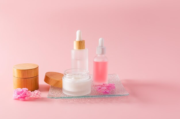 A set of cosmetic products for face and body skin care matte bottles of serum and an open jar of cream Natural cosmetics place for text