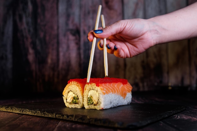 A set of delicious sushi rolls Sushi roll sticks are held in the hand