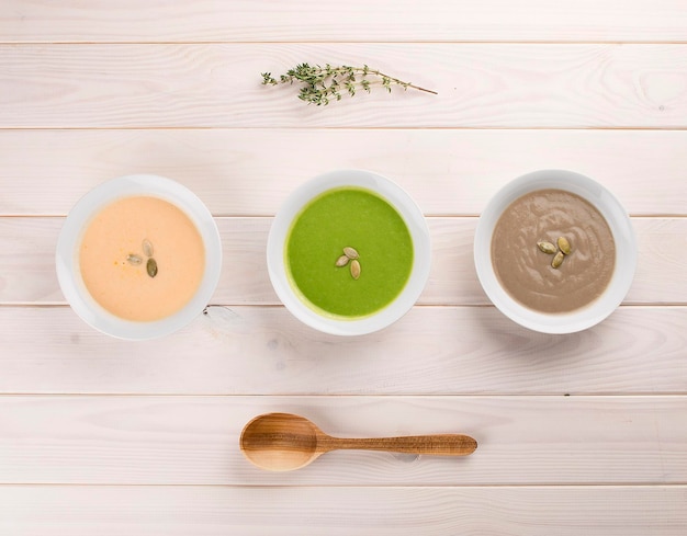 Set of diet cream soups on a light wooden background Broccoli pumpkin mushrooms Dietary and healthy food