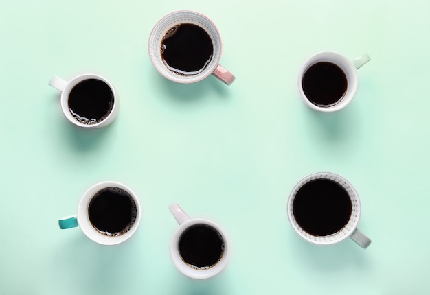 Set of different cups of coffee on mint background. Top view, copy space, flat lay.