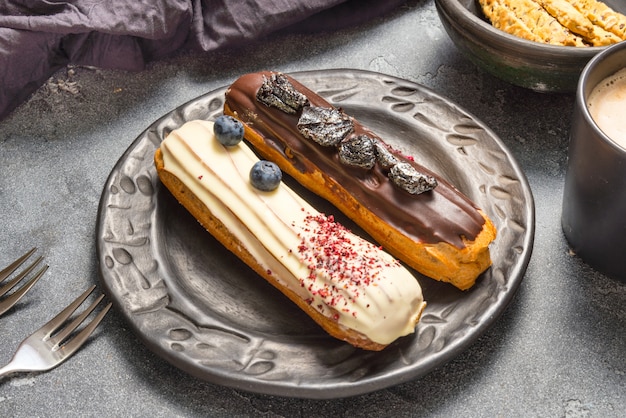 Set of different eclair cakes on dark backgrouns