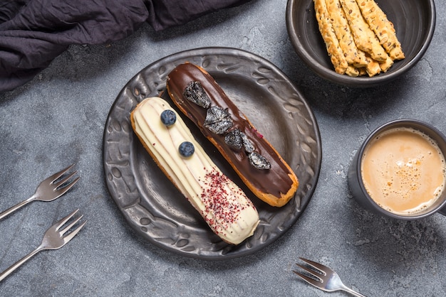 Set of different eclair cakes on dark backgrouns