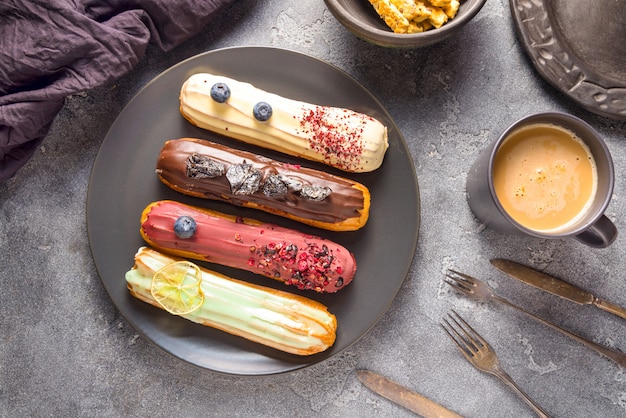 Set of different eclair cakes on dark backgrouns